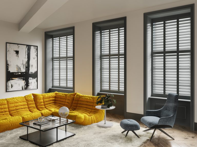 Modern living room with mustard yellow sectional sofa, tall shuttered windows, blue accent chair, and abstract wall art.